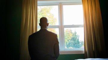 A listless man stares out the window
