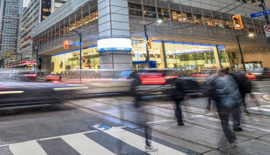 Long exposure photo with people in motion crossing busy city intersection