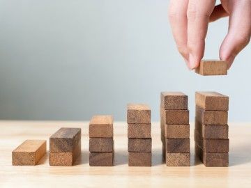 A close-up of a hand placing down building blocks