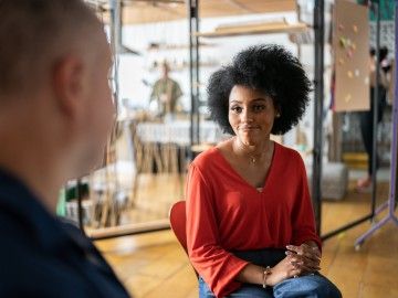 A woman smiles sympathetically at a colleague in an office