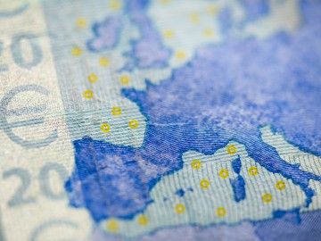 Close-up of Euro bill and map of Europe