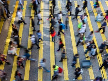 Overhead image of fast-moving pedestrians using a crosswalk to cross a road.