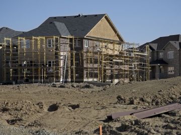 A residential home in mid-build is surrounded by scaffolding 