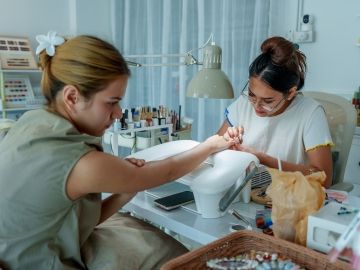 A nail technician works on a client's nails