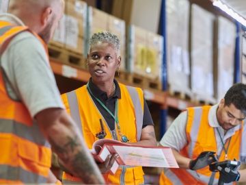 A warehouse manager delivers safety training to a worker