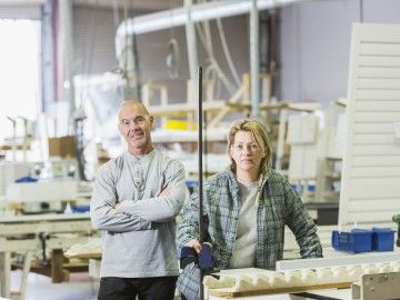 Two workers at a window shutters manufacturing shop floor