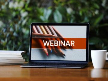 A laptop with the word "webinar" on the screen