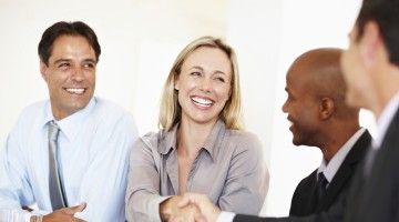 Businesswoman shakes hands with other professionals