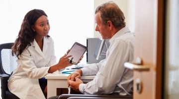 Doctor reviews checklist with patient in her office