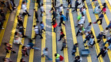 Overhead image of fast-moving pedestrians using a crosswalk to cross a road.