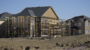 A residential home in mid-build is surrounded by scaffolding 