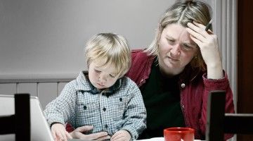 A mom at her dining table goes through bills