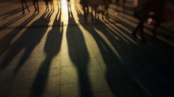 Long shadows cast by a row of workers