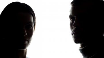 Silhouettes of a man and a woman looking straight ahead