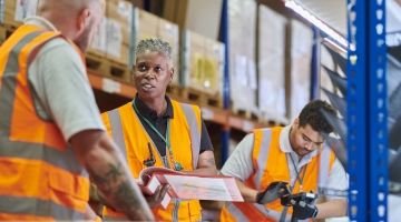 A warehouse manager delivers safety training to a worker
