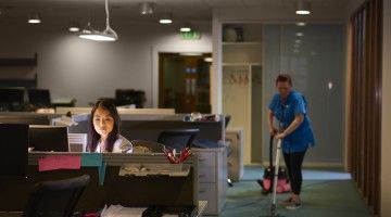 Office worker and cleaner during evening shift