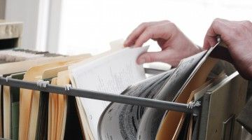 Close-up of hands rifling through hanging file folders