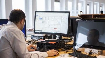 A man sits at his computer terminal