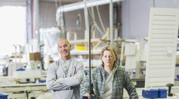 Two workers at a window shutters manufacturing shop floor