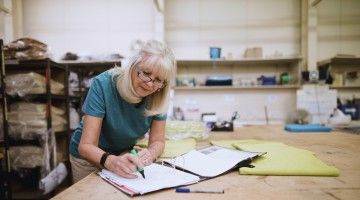 An older woman works in a workshop