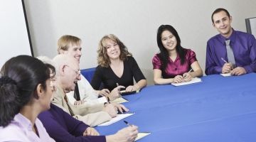 People around a table, discussing