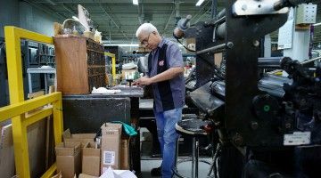 Older man works in print shop