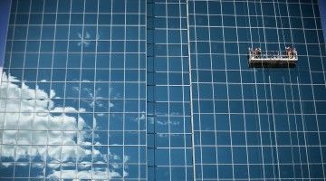 Window cleaners against mirrored skyscraper