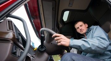 A view from below of truck driver behind steering wheel