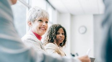 Female colleagues smiling at a meeting  