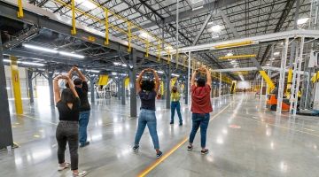 Group of warehouse workers doing stretching exercises