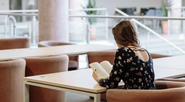 A view from the back of a woman reading a book