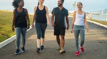 Four people walking for exercise, in track wear and running shoes