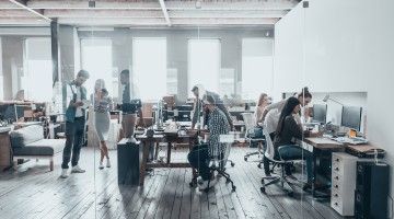 men and women sitting and standing at work