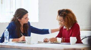 A supervisor has a supportive chat with a worker