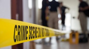 Investigators working behind crime-scene yellow tape
