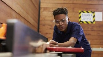 Carpenter Using Plane In Woodworking Woodshop