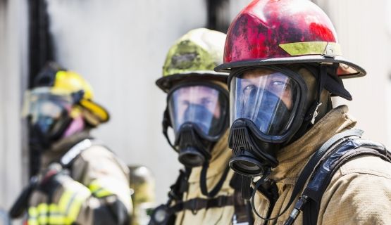 Three firefighters in their equipment are pictured.