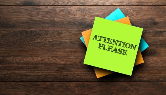 sticky note displaying words attention please