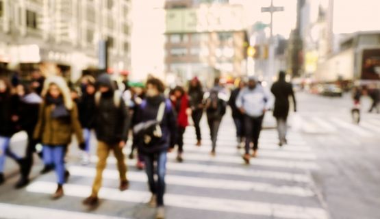 A blurry image of a busy sidewalk crossing