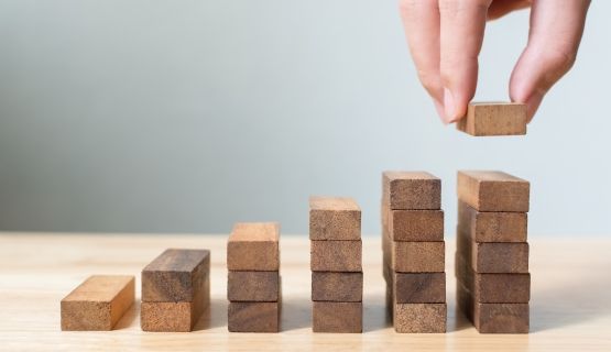 A close-up of a hand placing down building blocks