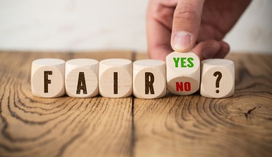 Wooden blocks spell out the words 'fair,' and 'yes or no?'