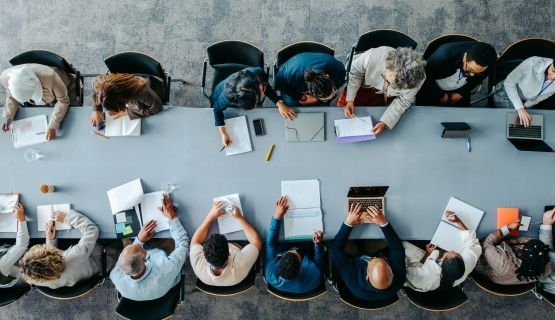 An overhead shot of a boardroom table full of people