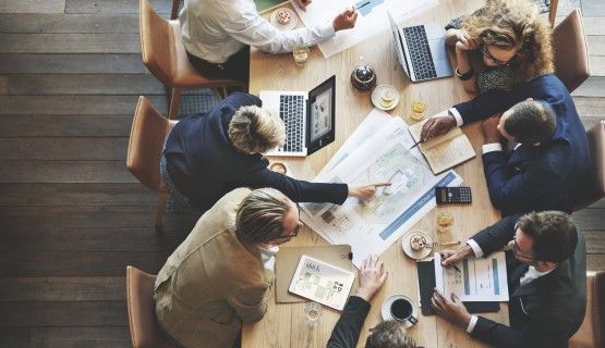 Stakeholders discuss idea around conference table Thumbnail