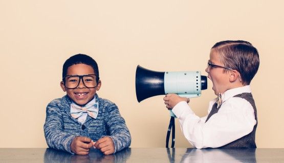 Boy shouting through megaphone to another boy Thumbnail