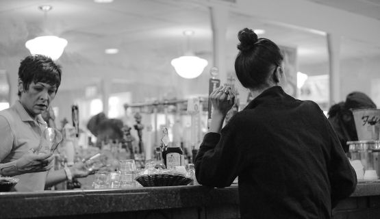 Two female servers at a restaurant bar