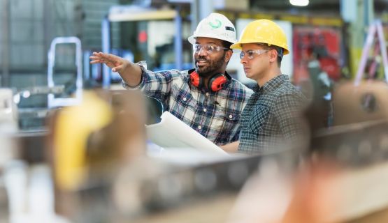 two workers looking over a plan