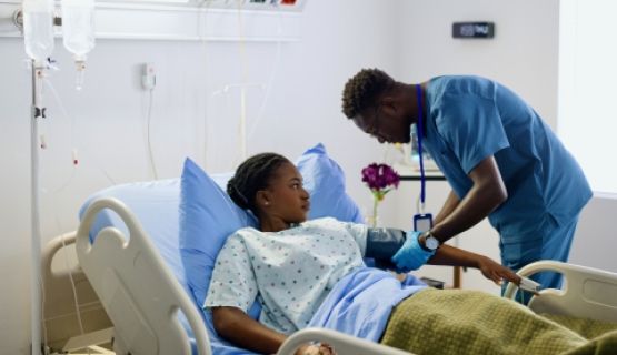 A nurse takes his patient's blood pressure.