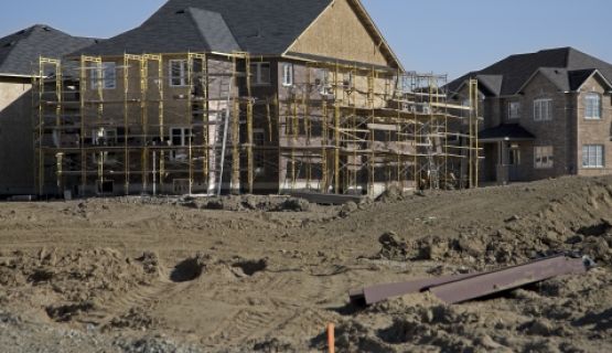 A residential home in mid-build is surrounded by scaffolding 