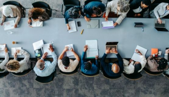 An overhead shot of a boardroom table full of people