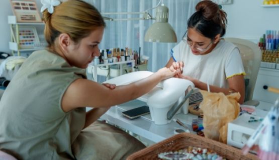 A nail technician works on a client's nails